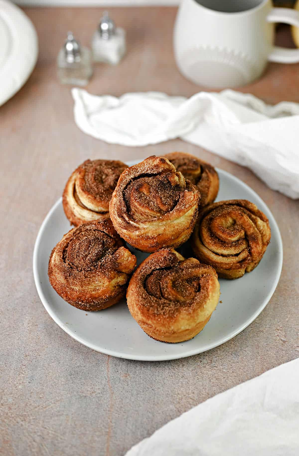 6 cinnamon cruffins on a small plate.