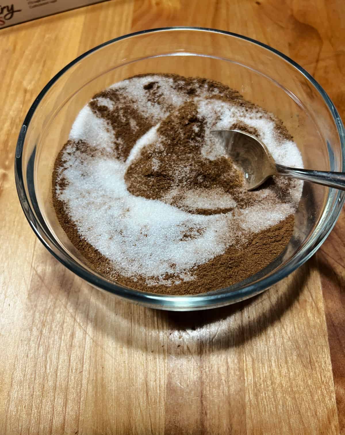 Mixing cinnamon and sugar in a small bowl.