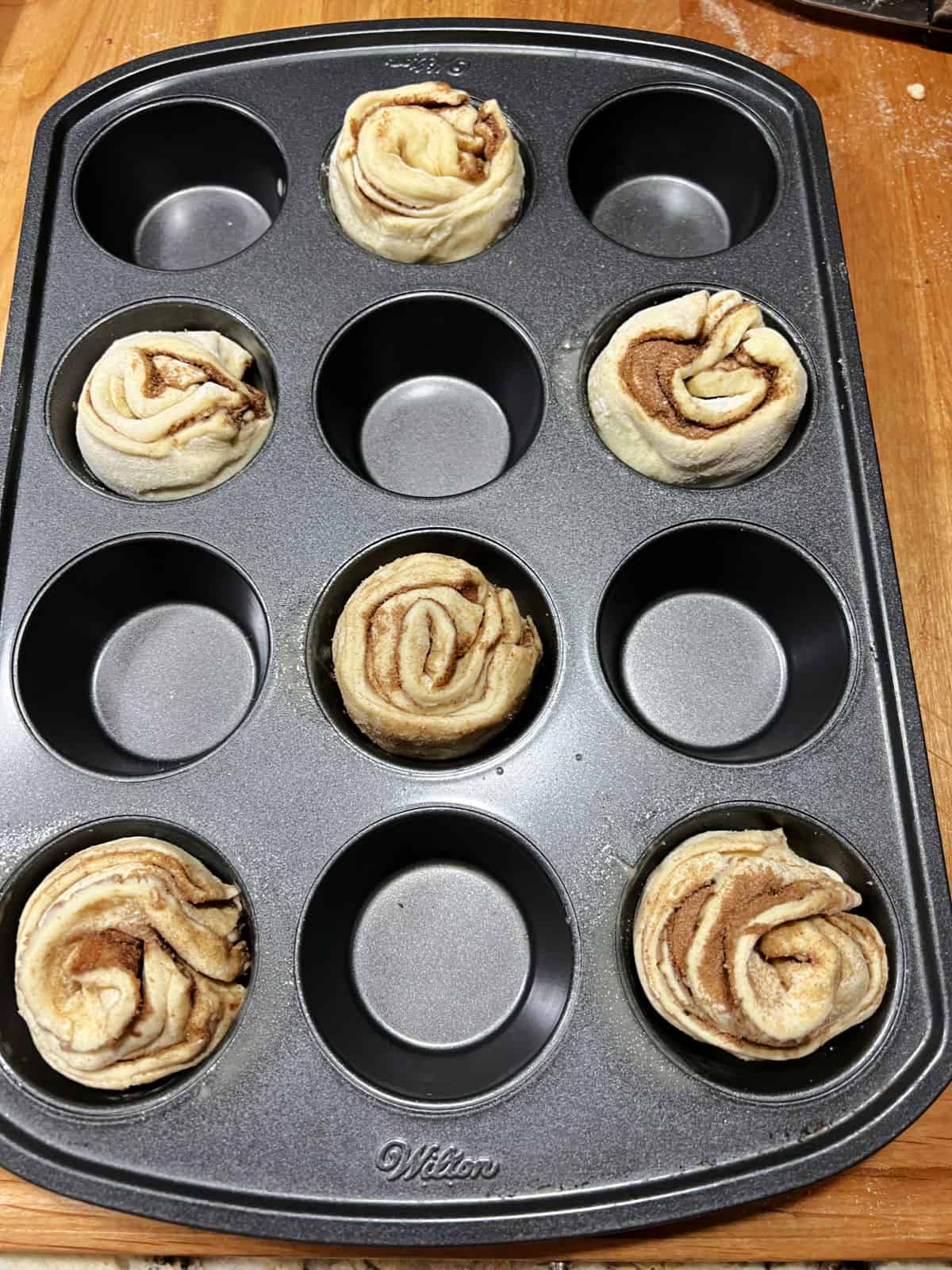 6 unbaked cruffins in a muffin pan, ready to bake.