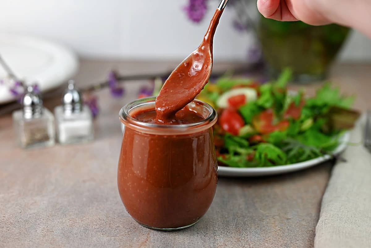 A small jar of strawberry vinaigrette dressing.