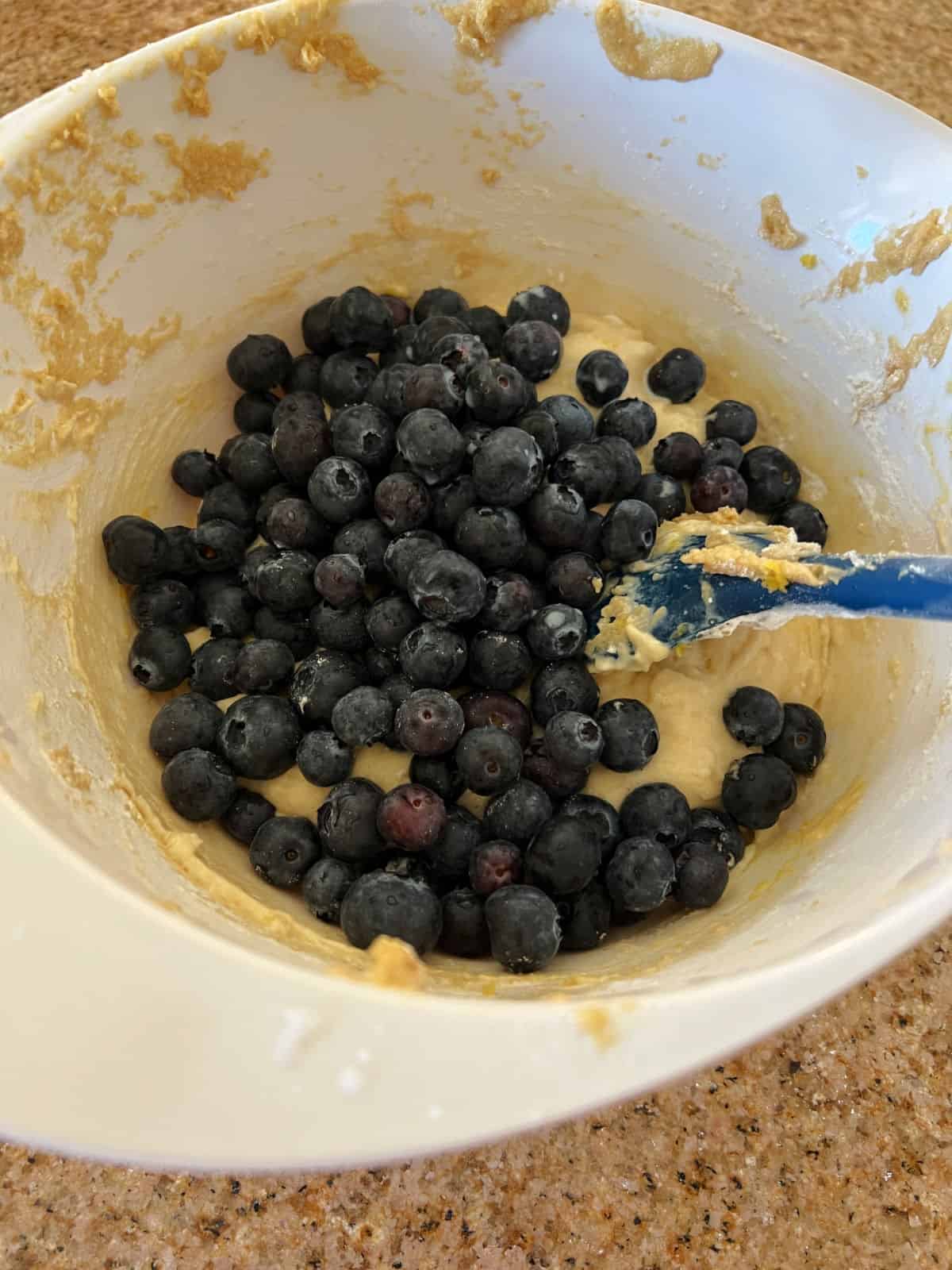 blueberries added to the bowl of batter.