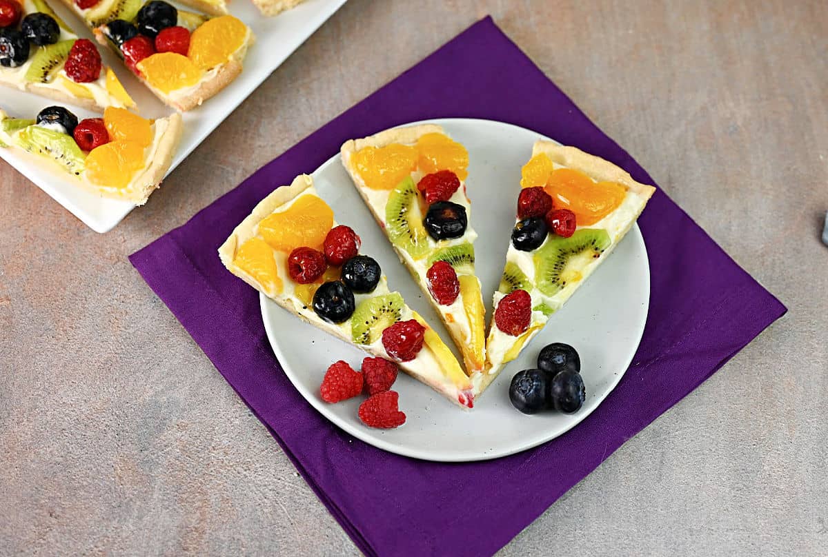 3 slices of fruit pizza on a small plate, ready to eat!