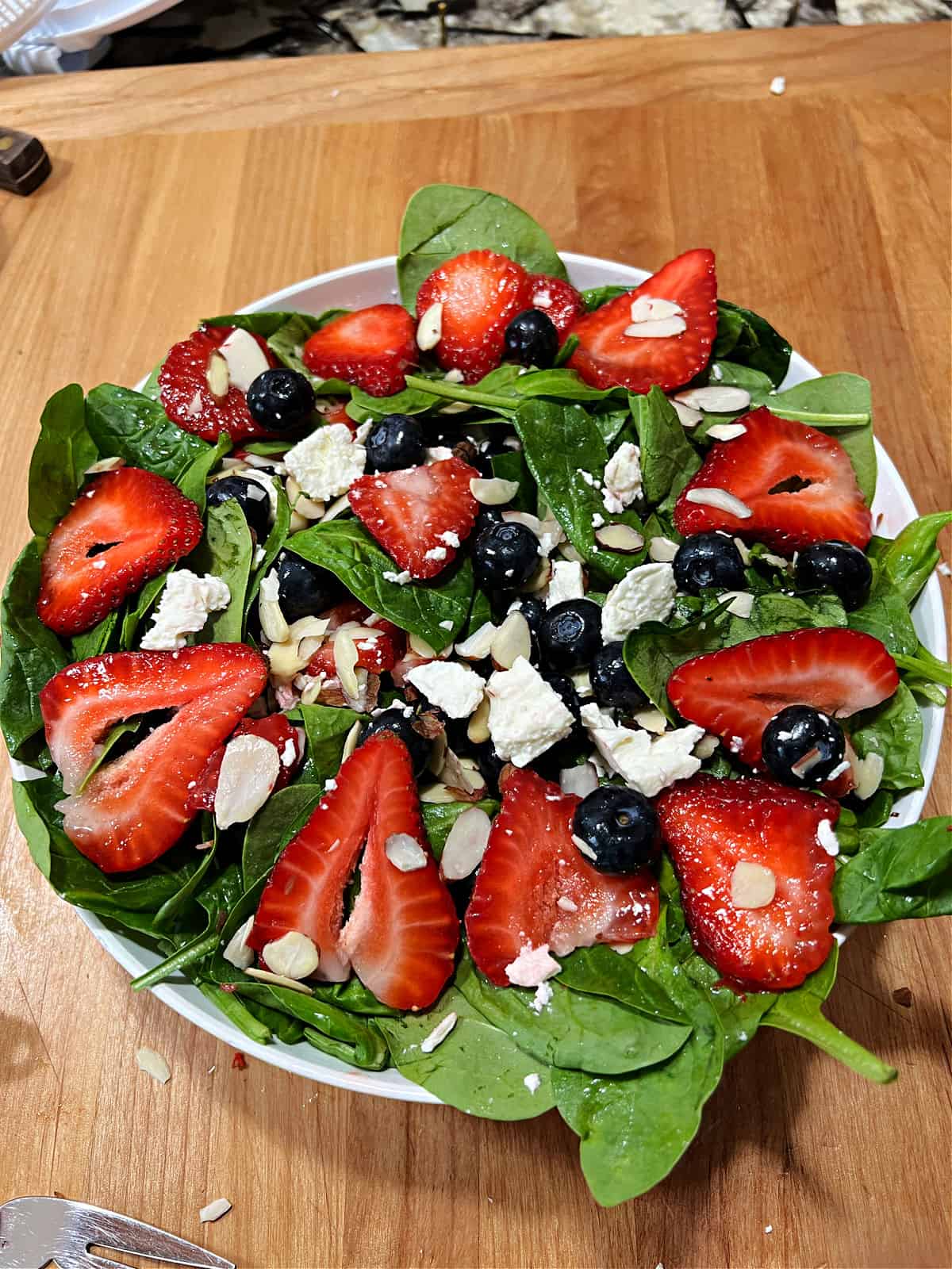 Blueberry strawberry and spinach salad tossed in the bowl.