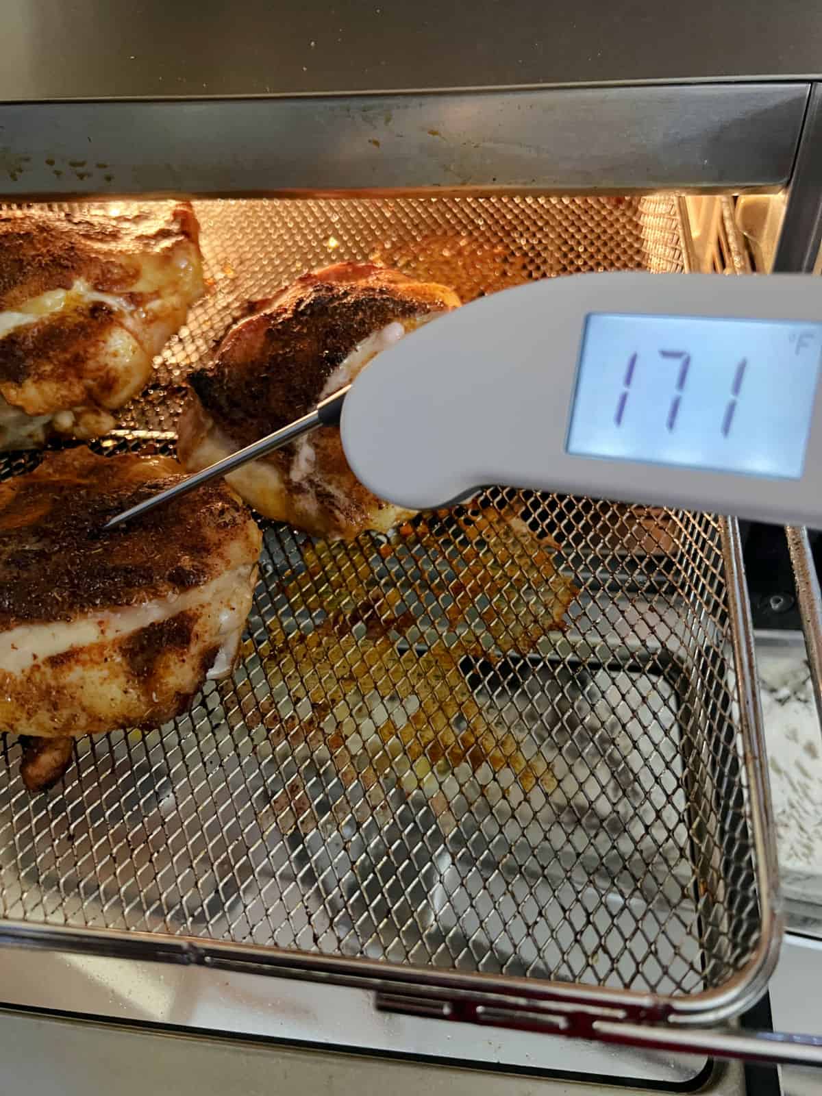 using a meat thermometer to check internal temperature.