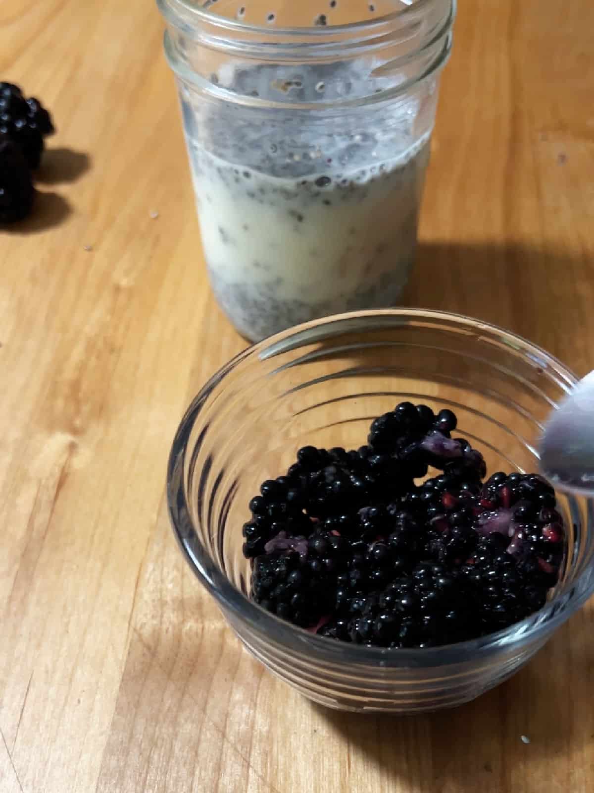 Mashing blackberries in a small bowl.