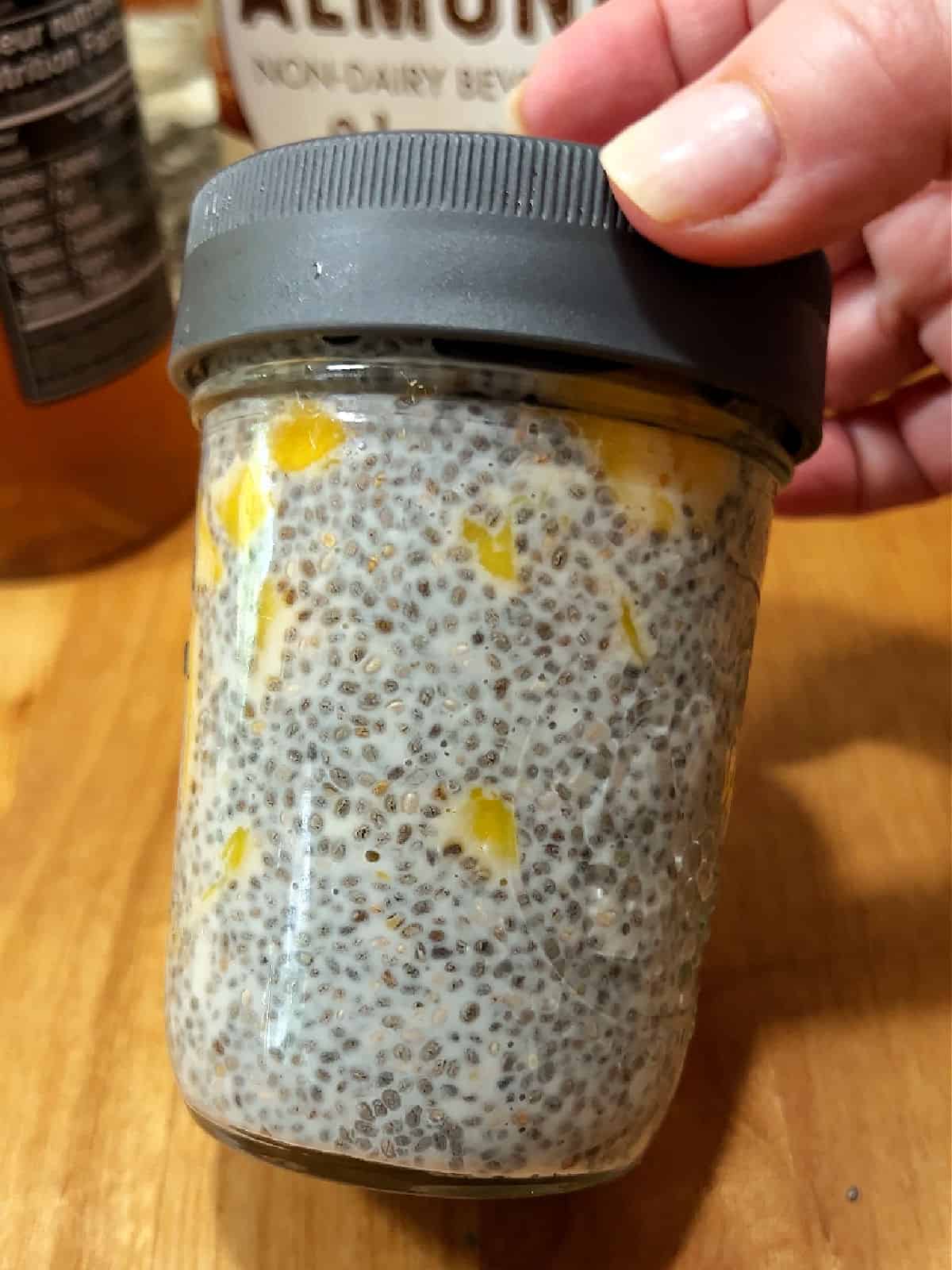 Covered jar of mango chia pudding ready to refrigerate.