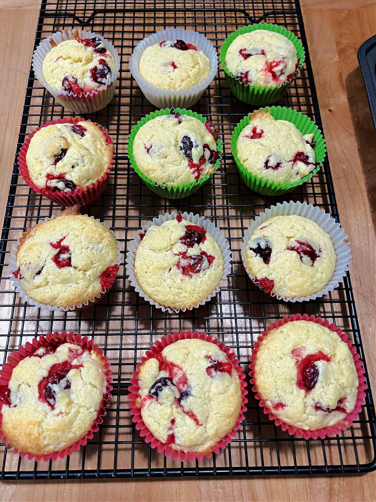 Cranberry cream cheese muffins cooling on a wire rack.