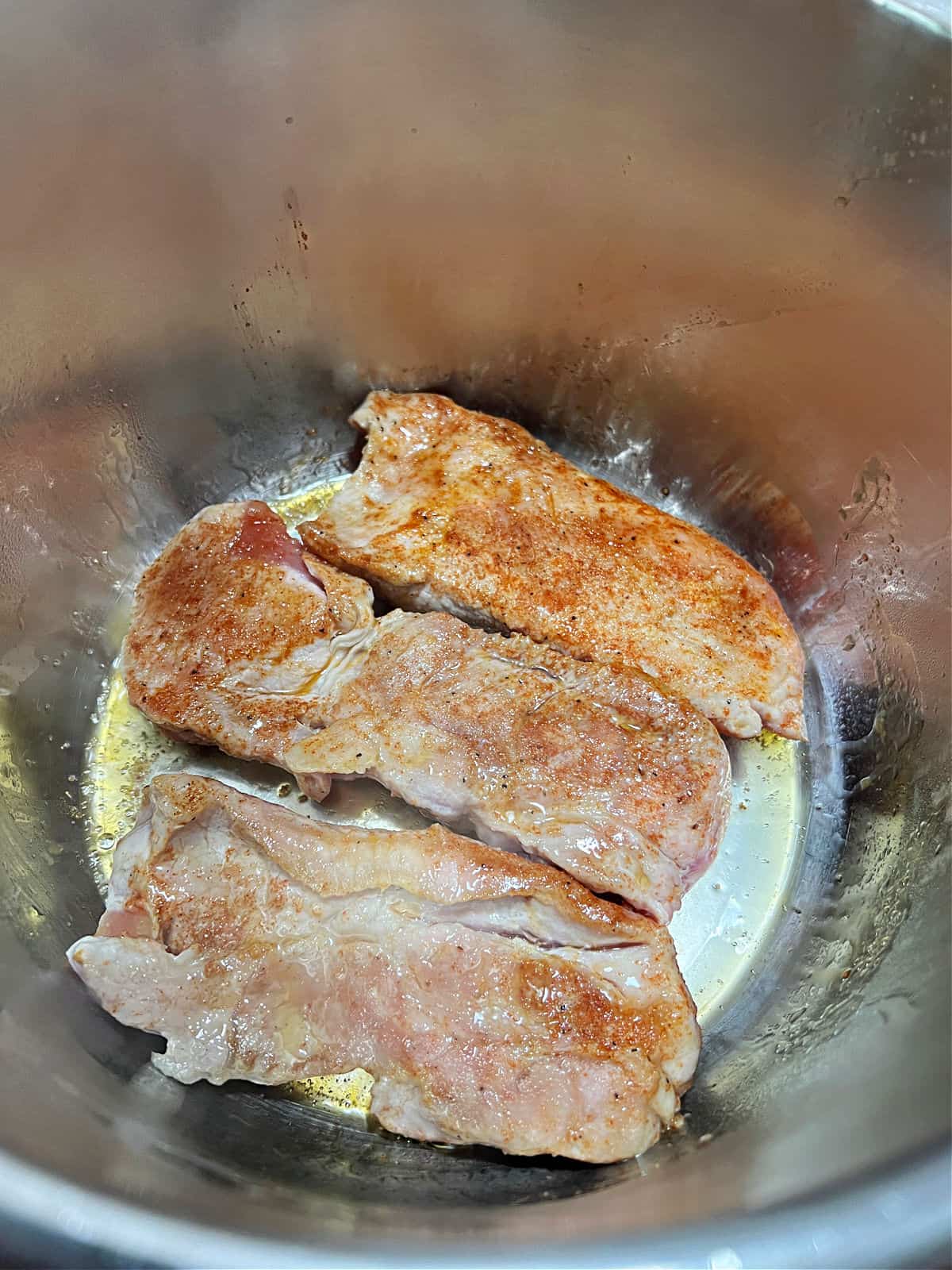 Strips of pork searing in the Instant Pot.