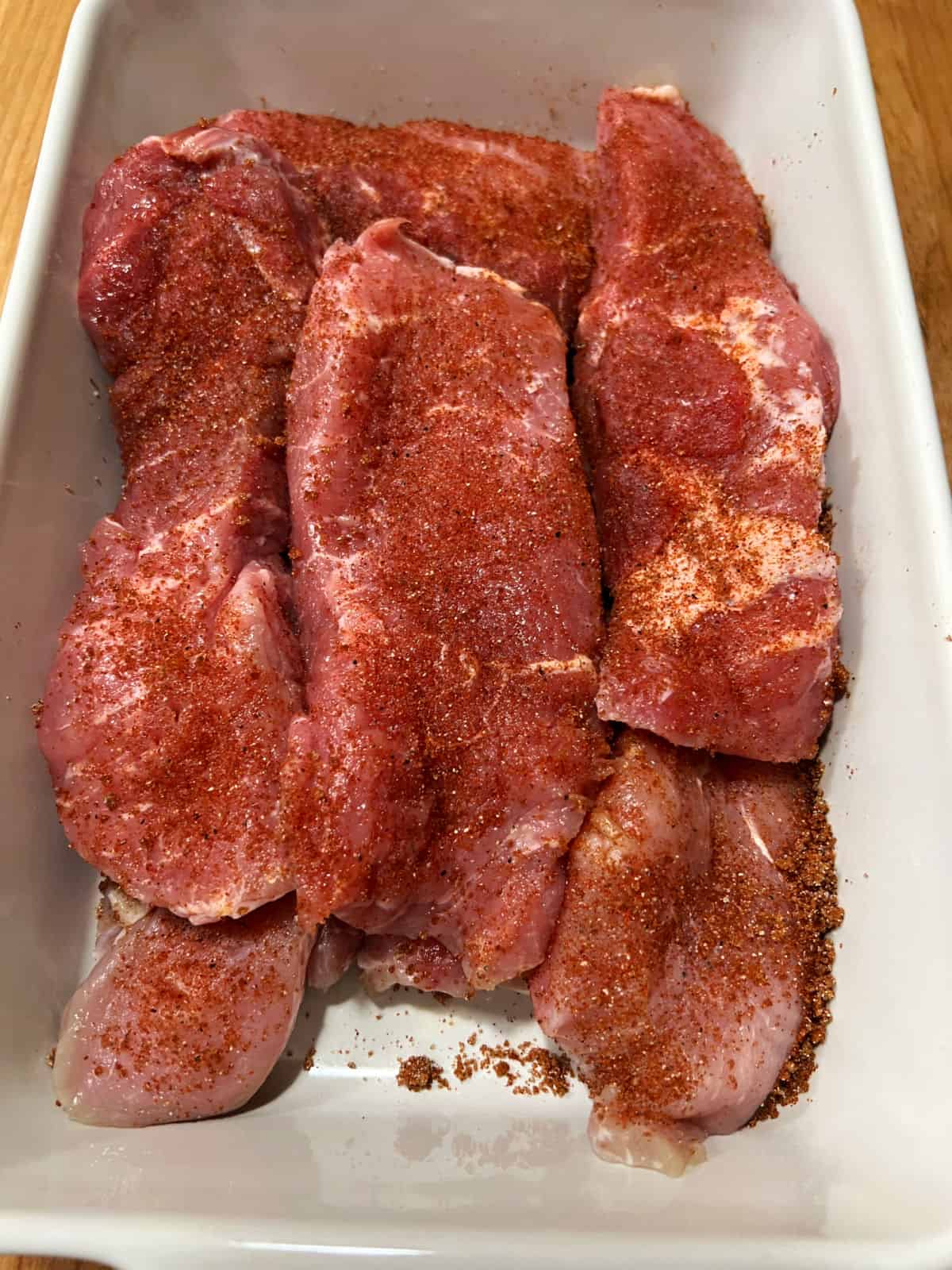 Pan full of meat seasoned with dry rub.