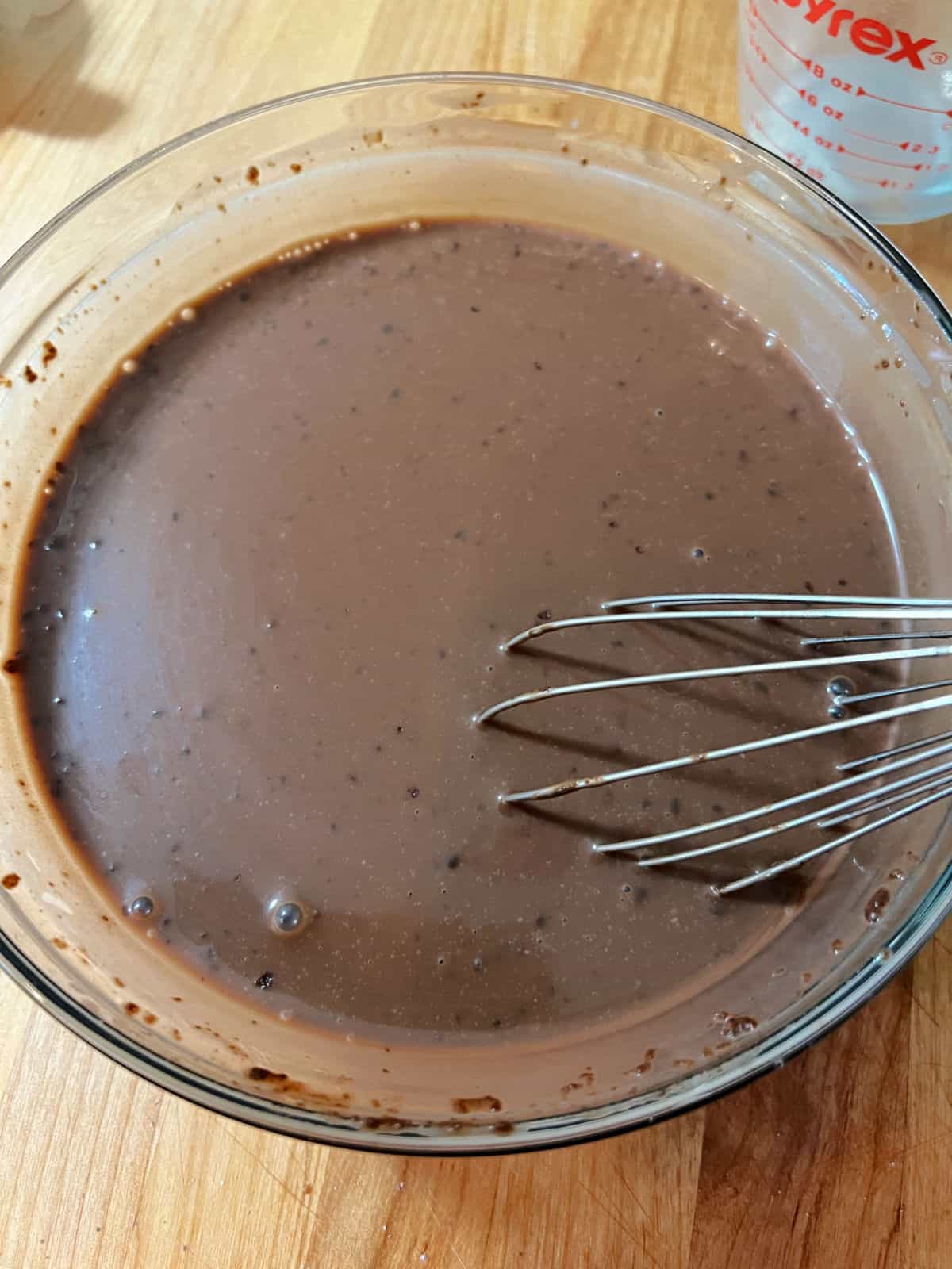 Dry pudding mix being whisked into the milk.