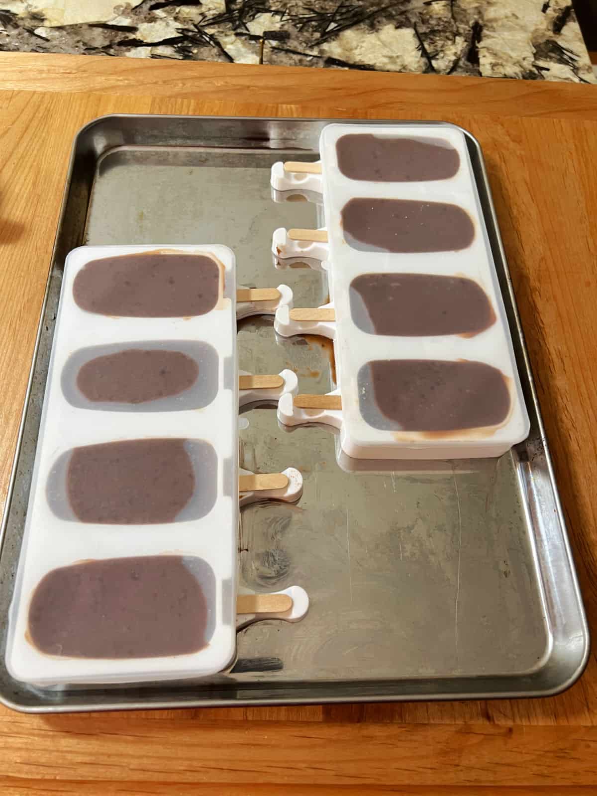 Molds filled with the fudgesicle mix and ready to freeze.