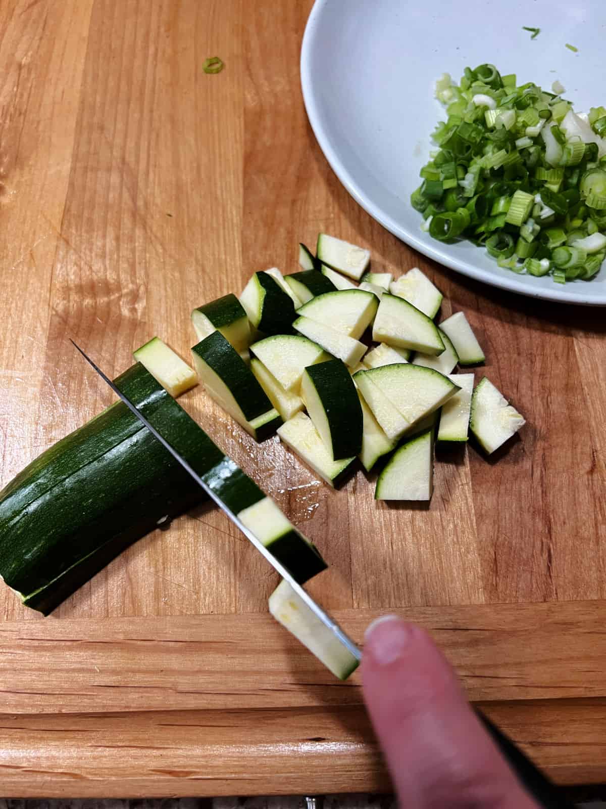 Chopping zucchini.