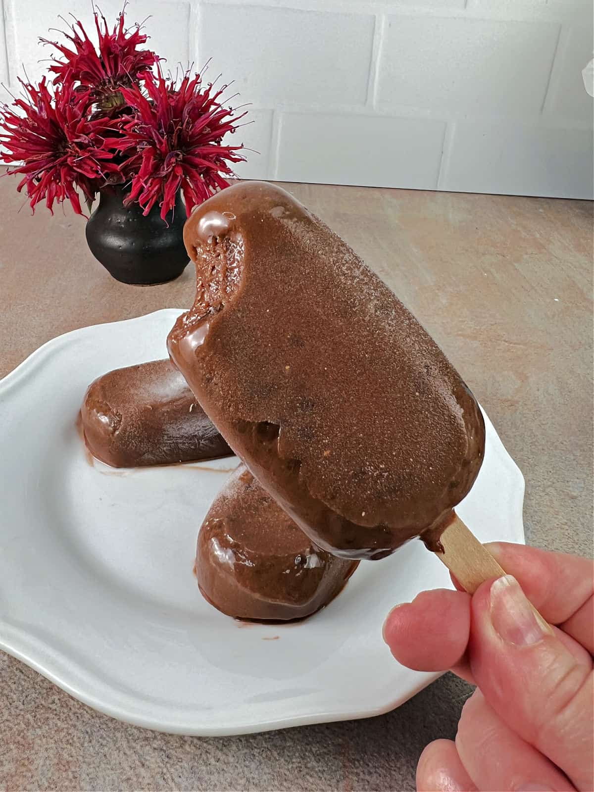 Homemade fudgesicle with a bite taken.