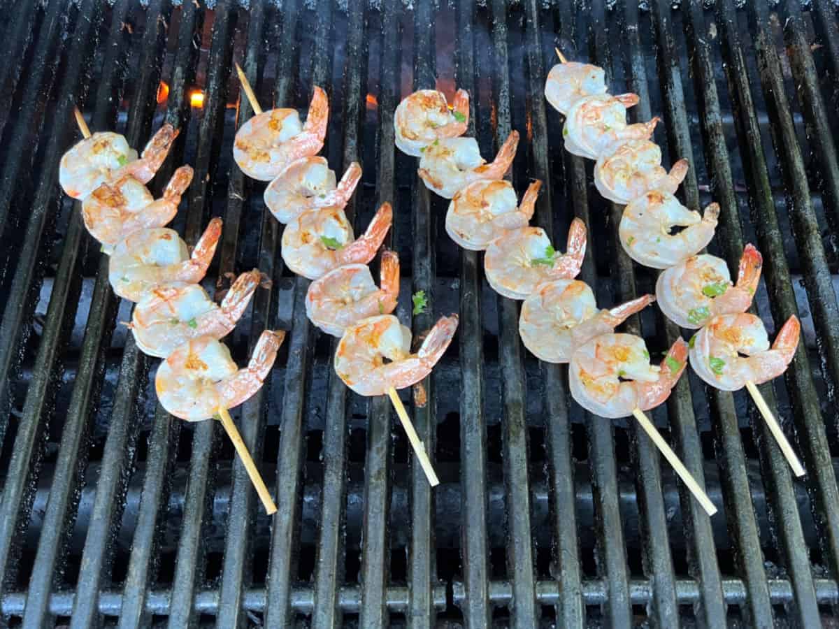 Shrimp skewers cooking on a grill.
