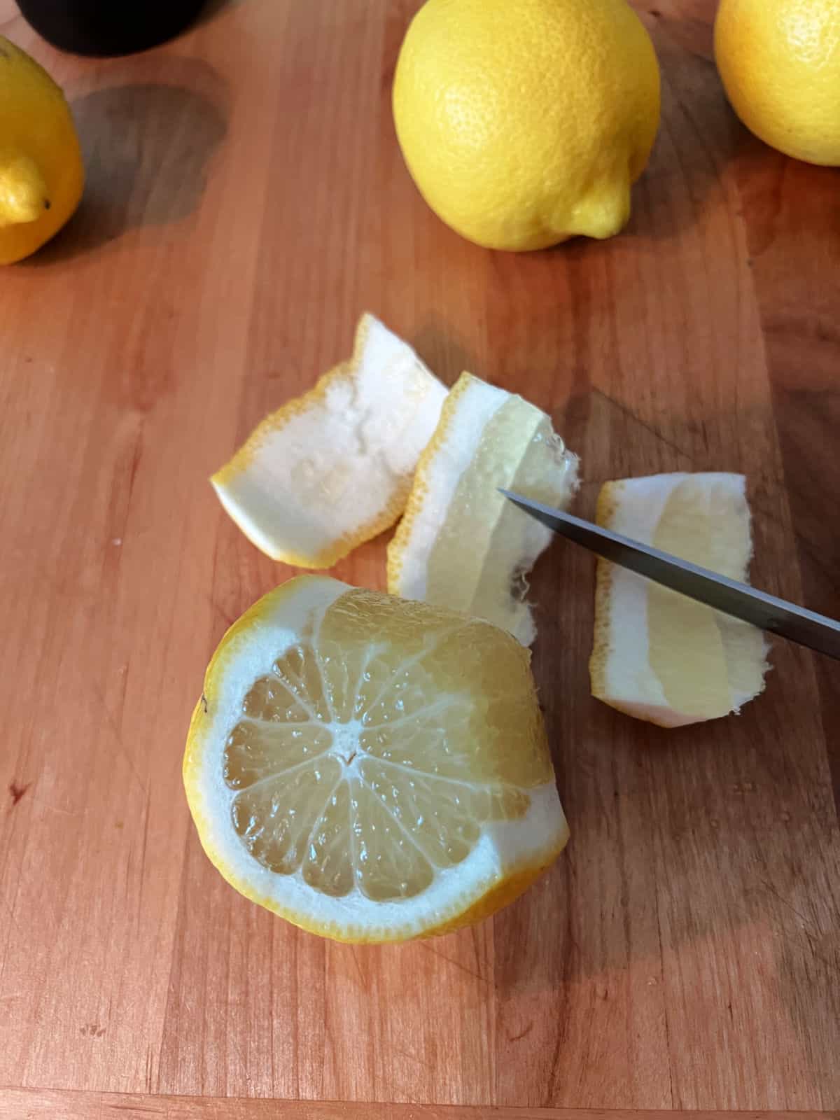 Cutting the peel from a whole lemon.