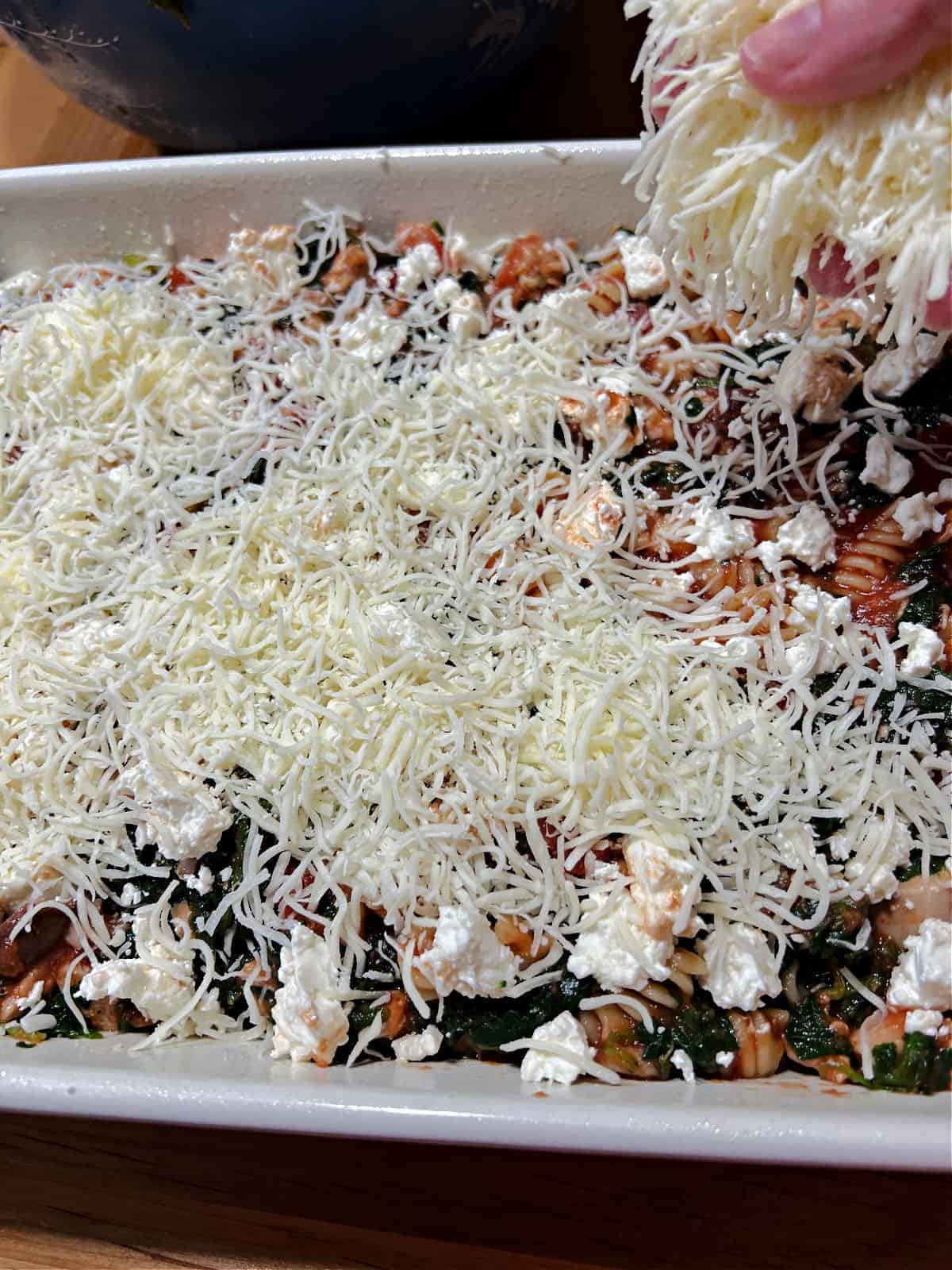 Adding cheese to the top of the casserole.