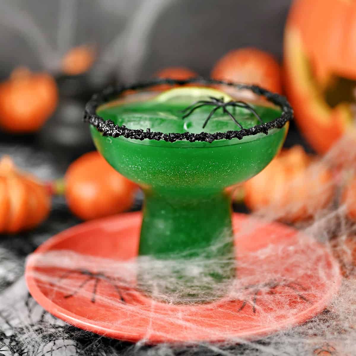 Poison Apple Margarita surrounded by spider webs and spiders.