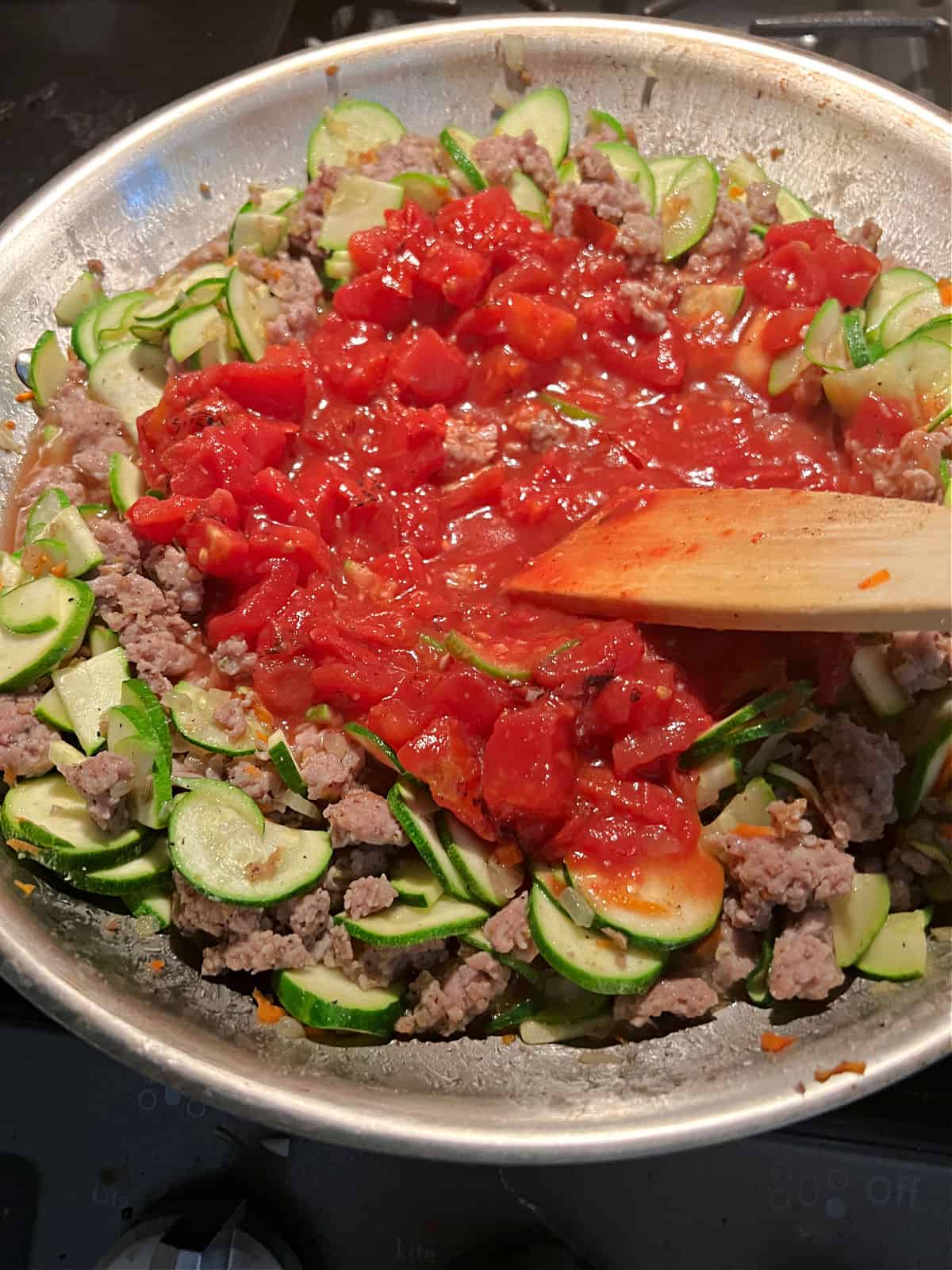 Adding tomatoes to make a sauce.