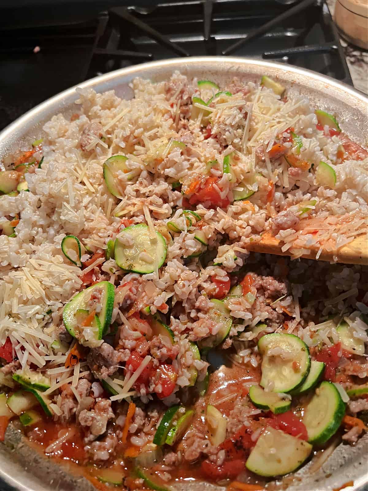 Adding rice and Parmesan to the skillet.