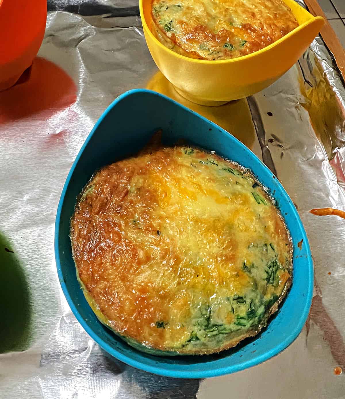 Browned egg bite in a blue silicone mold.