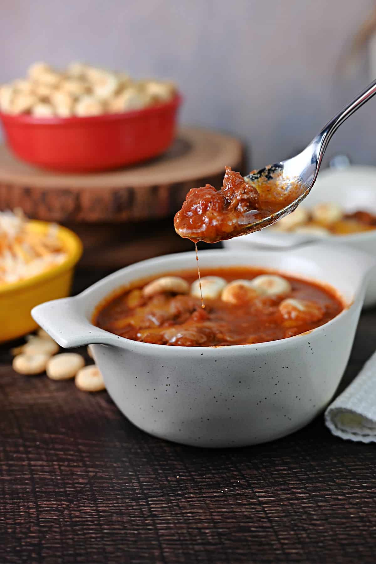 Spoon of chili dripping slightly back into the bowl.