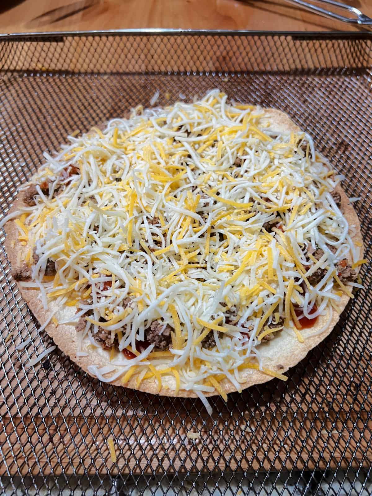 Cheese covering the uncooked pizza.