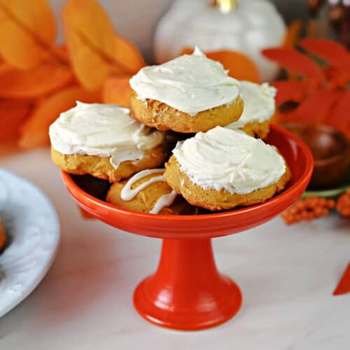 Small dish with a stack of old fashioned pumpkin cookies, frosted with cream cheese frosting and ready to eat!