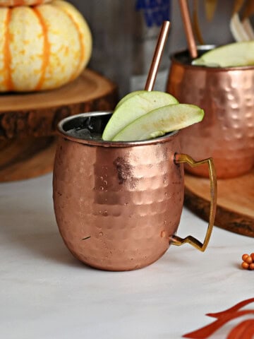 2 apple cider Moscow mules in copper mugs.