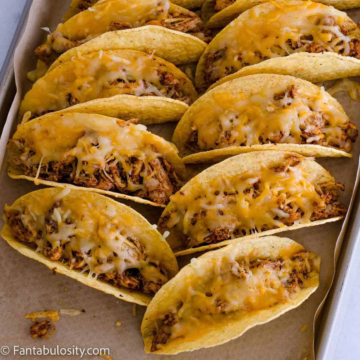 crispy chicken tacos on a baking sheet.