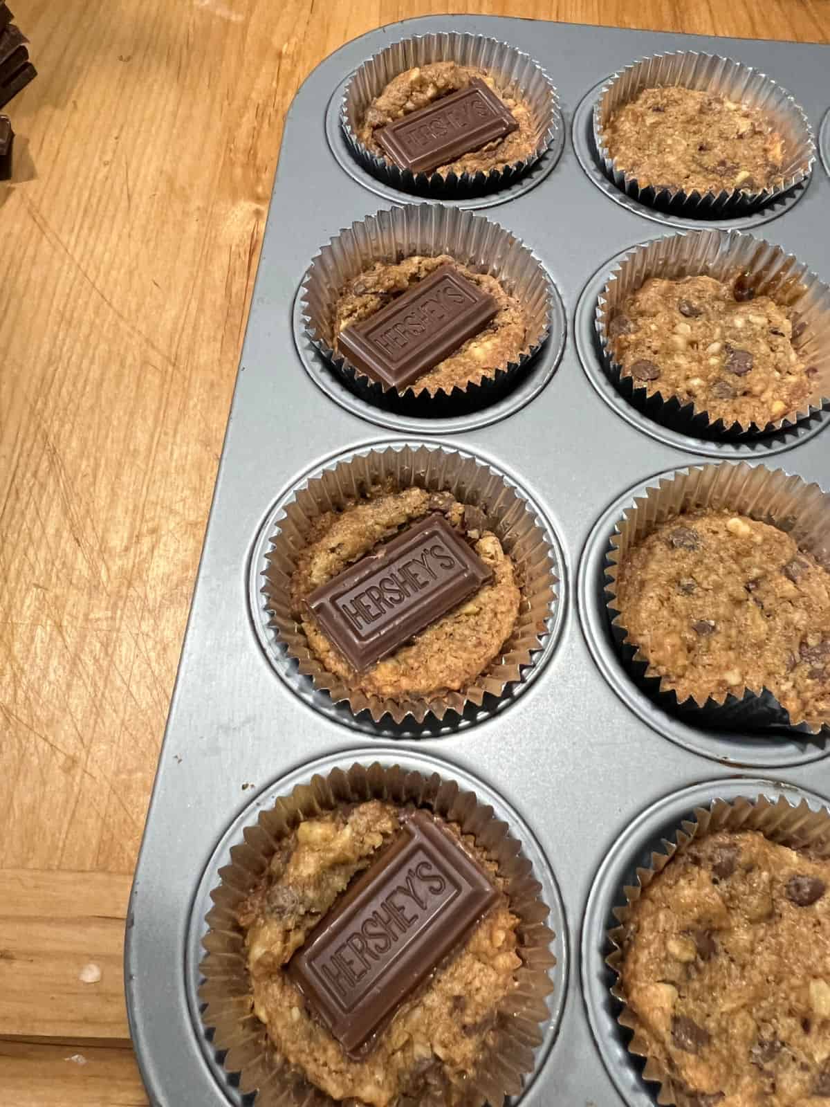 placing a piece of chocolate bar on top of each warm cookie.