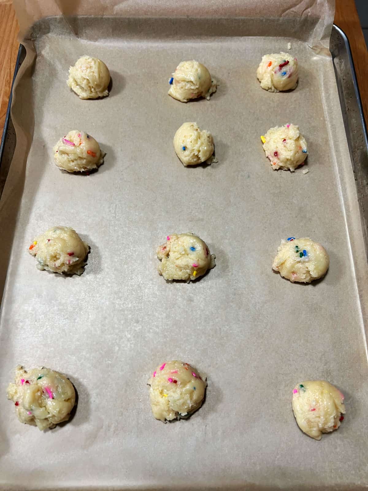 Balls of dough spaced apart on baking sheet.