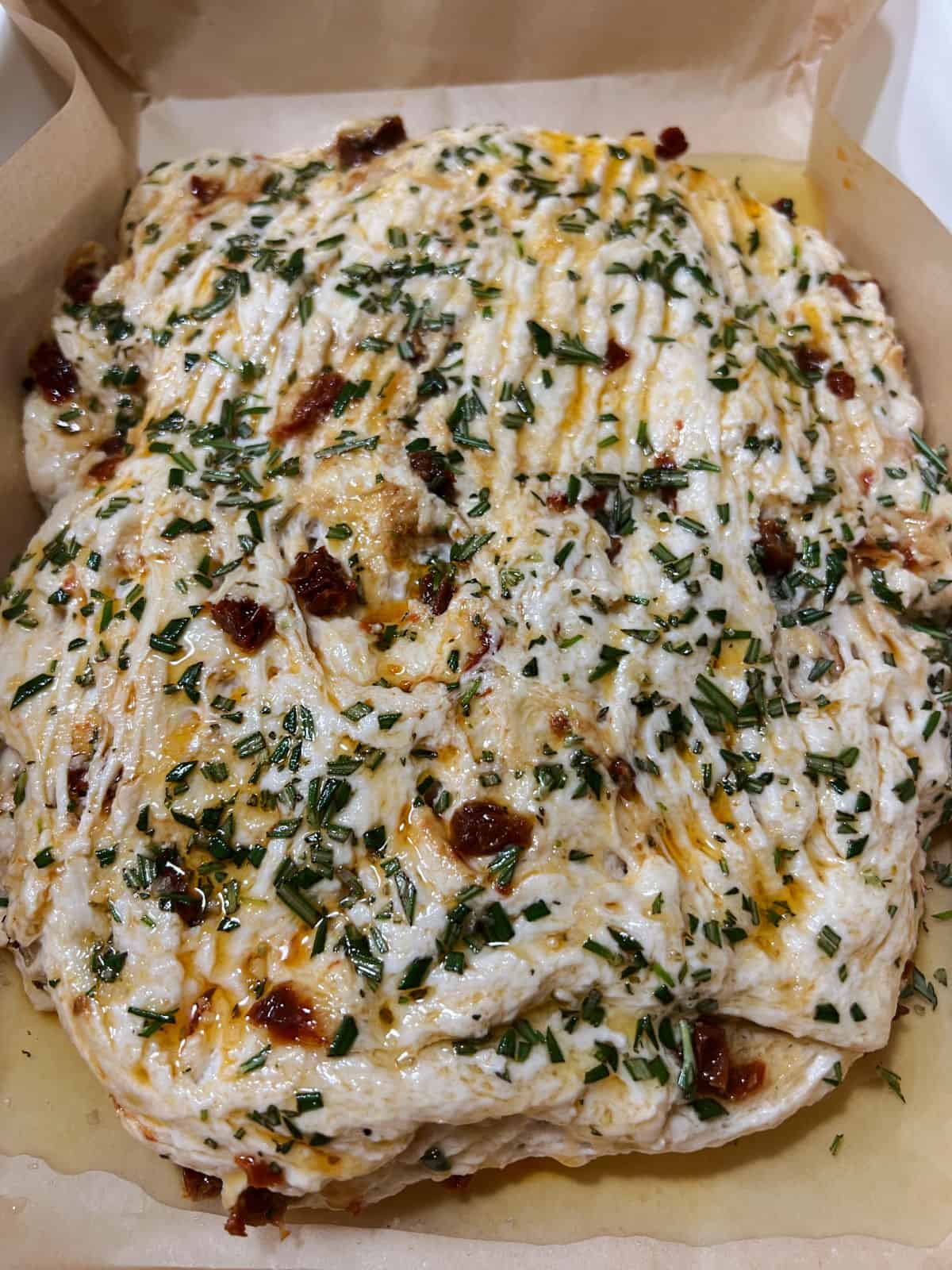 shaped dough in the lined baking pan, sprinkled with rosemary and flaky salt.