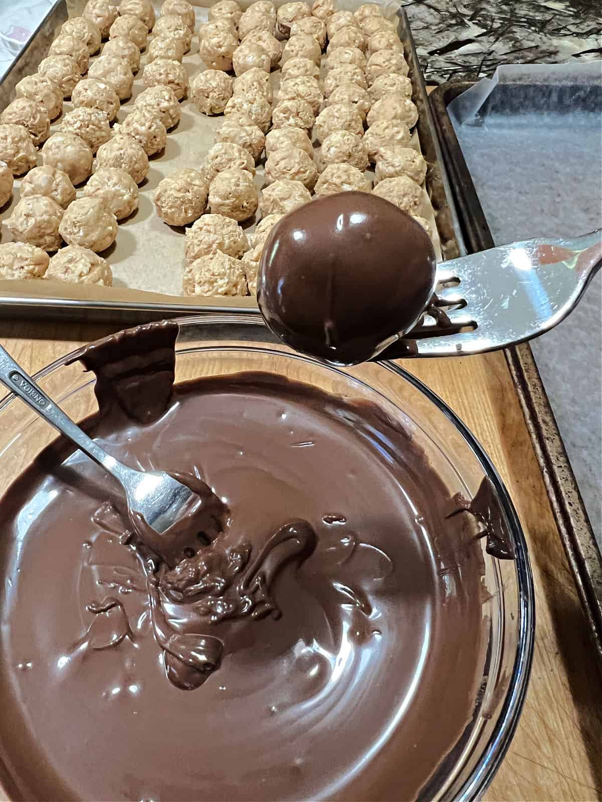 coated ball lifted out of the chocolate.