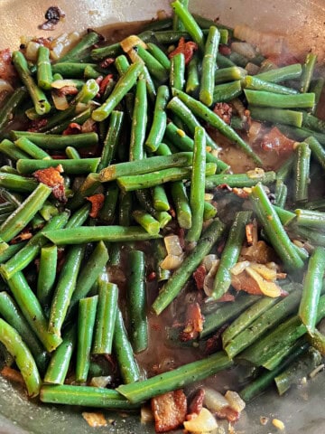 Texas Roadhouse copycat green beans cooking in a skillet.