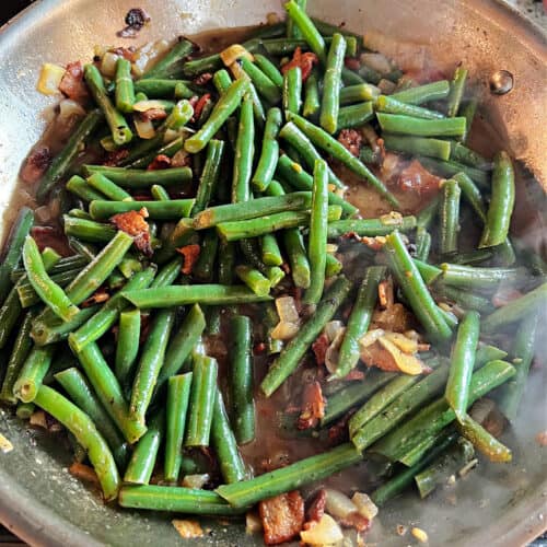 Texas Roadhouse copycat green beans cooking in a skillet.