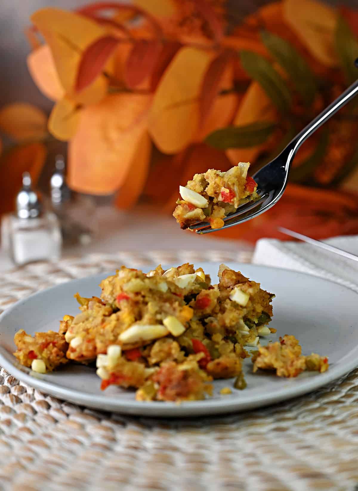 Fork holding some cornbread dressing and showing the egg.