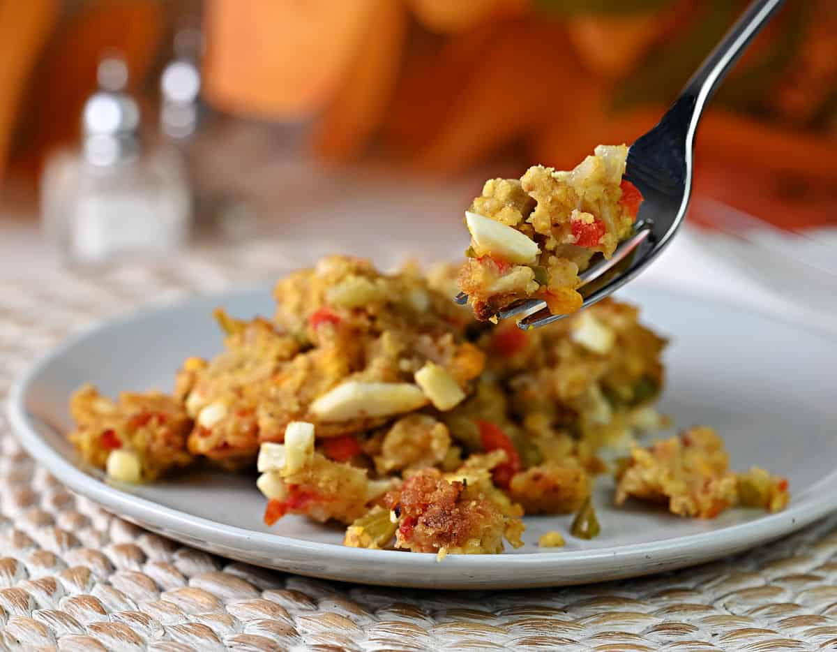 close up of a fork holding the cornbread dressing, you can see the details including the hard boiled eggs.