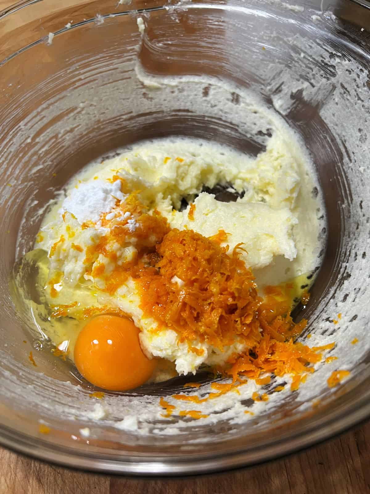 Adding orange zest and egg to the bowl.
