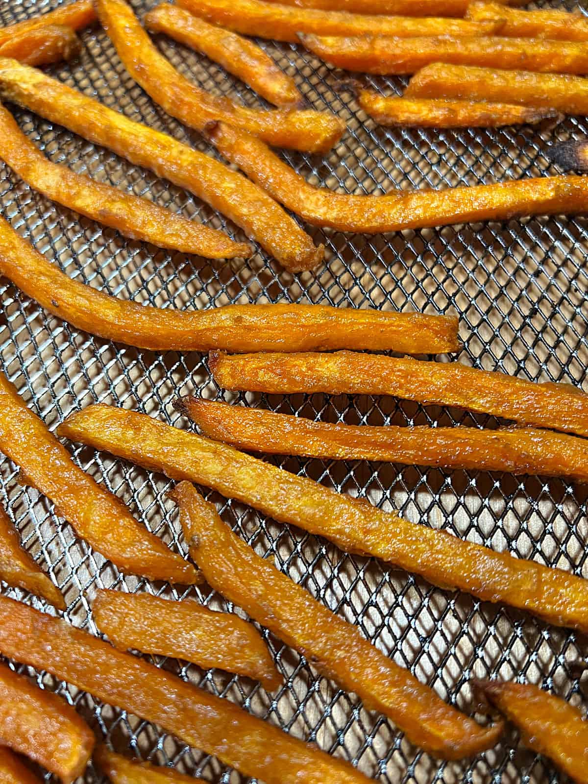Close up of Alexia sweet potato fries in an air fryer basker.