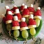 a small plate of fruit Grinch kabobs ready to serve.
