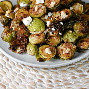 plate of roasted Brussels sprouts with goat cheese and a drizzle of balsamic.