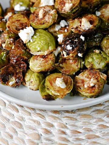 plate of roasted Brussels sprouts with goat cheese and a drizzle of balsamic.
