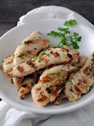 a shallow bowl of grilled healthy chicken tenderloins, ready to eat.