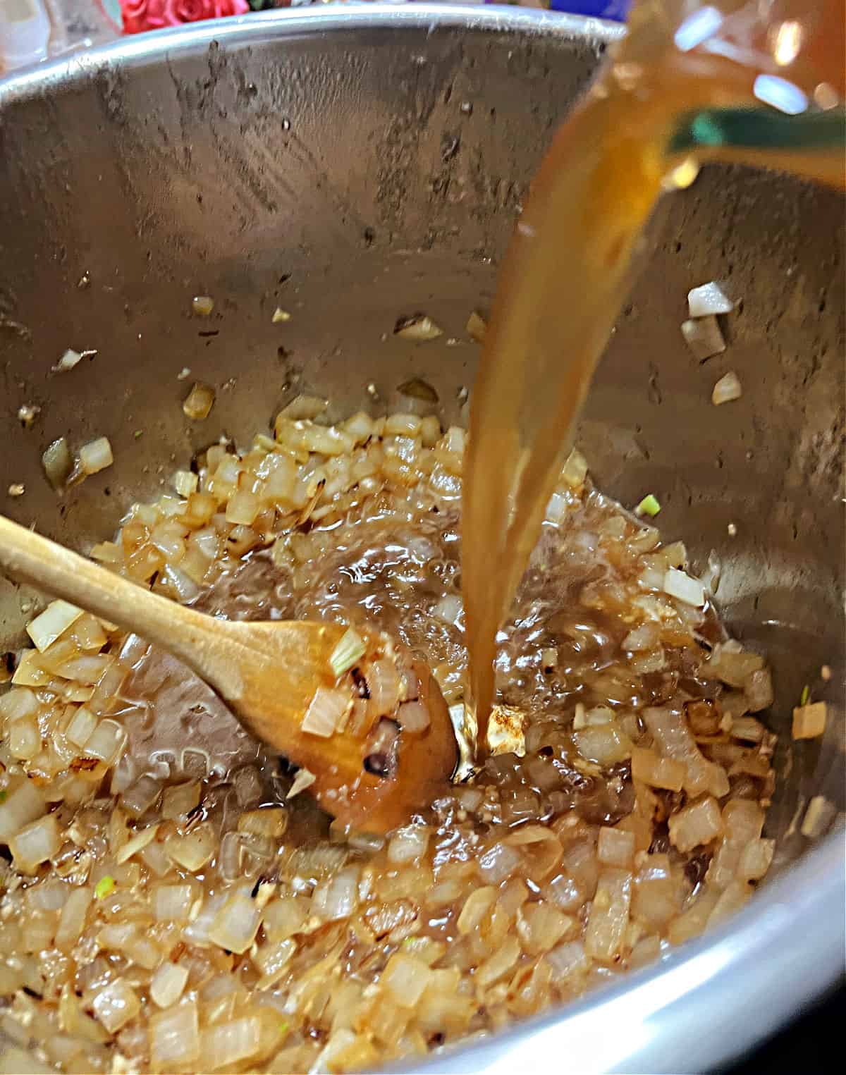 Adding broth to the pot.