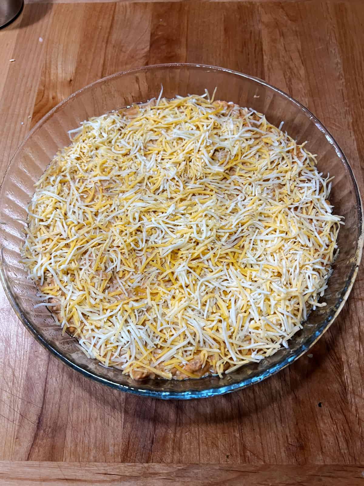 Dip in a baking dish topped with shredded cheese.