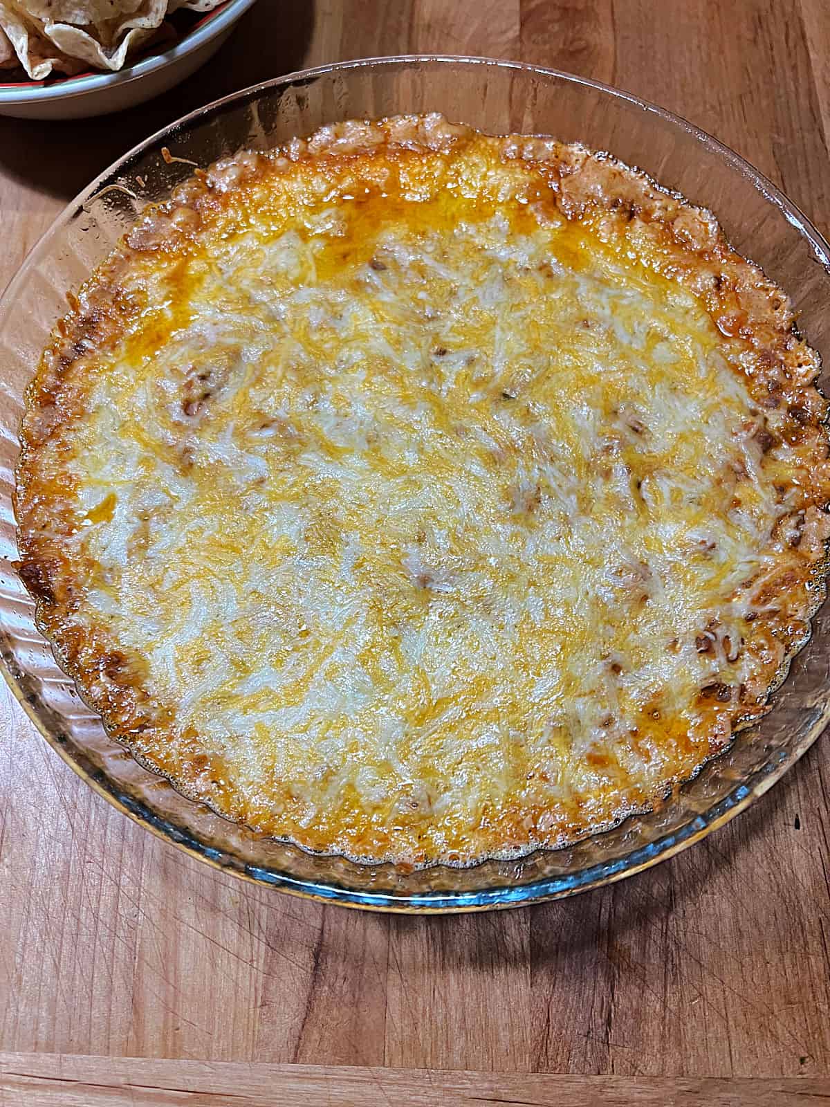 Hot baked taco dip with bubbly edges and melted cheese.