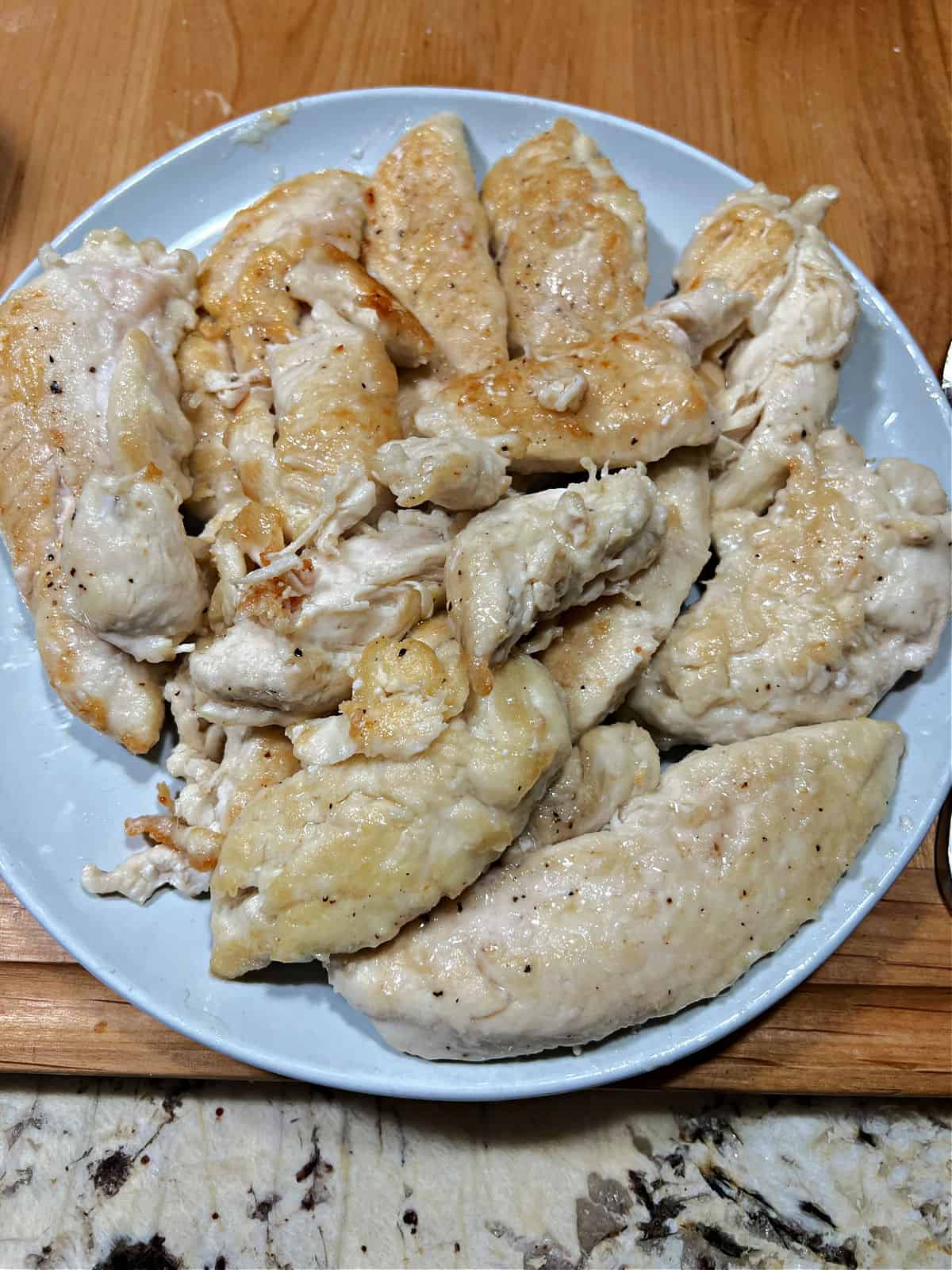 Cooked chicken tenders on a plate.