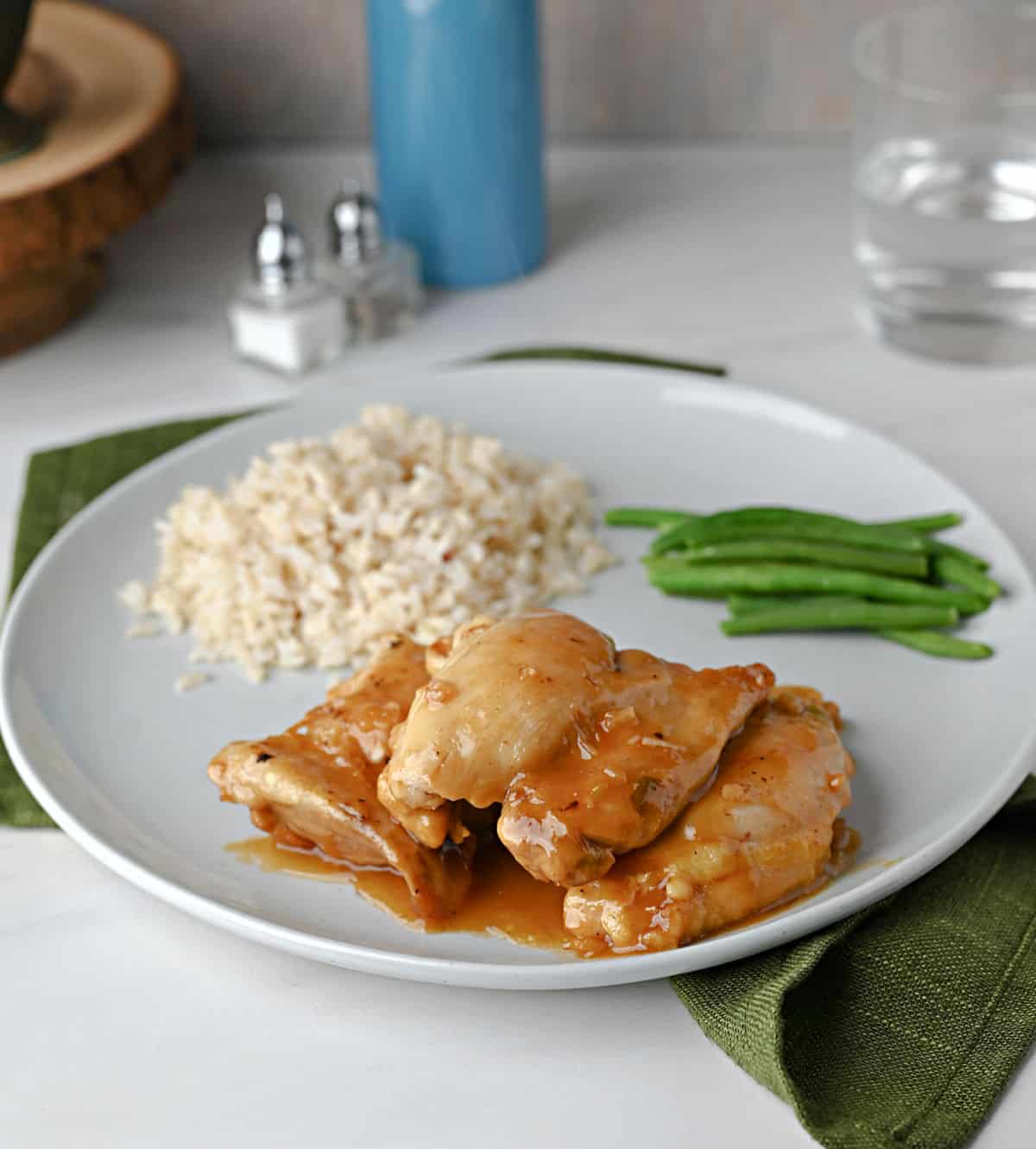 A plate with apricot chicken, brown rice, and green beans ready to eat.