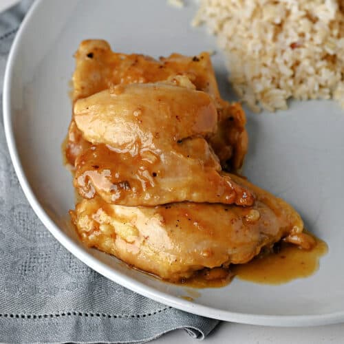 3 chicken thighs with apricot sauce on a plate ready to eat.
