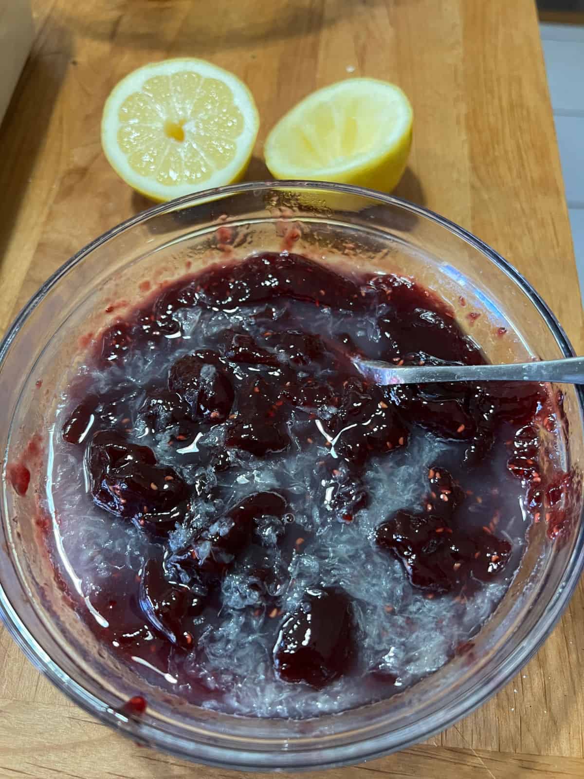 Adding lemon juice to raspberry jam.